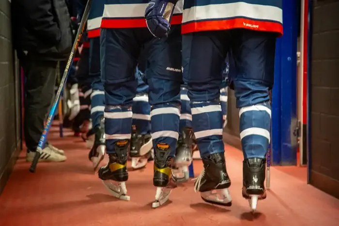Benen på ishockeyspelare i en korridor. 